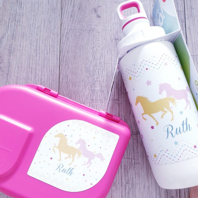 Rosa Lunchbox und Wasserflasche mit Pferdemotiven und dem Namen Ruth.