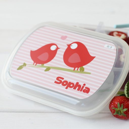 Bento-Box mit roten Vögeln und dem Namen "Sophia" auf einem gestreiften Hintergrund.