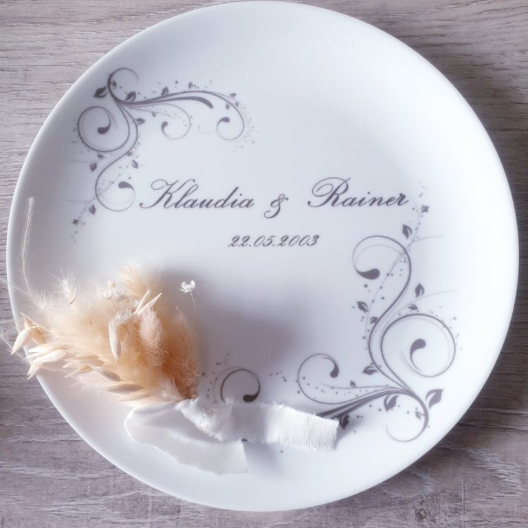 Hochzeitsteller mit Aufschrift „Klaudia & Rainer“ und dekorativen Verzierungen.